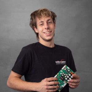 Till Ebnöther, Service-Techniker bei der WILUX PRINT AG, mit einer Leiterplatte in den Händen.
